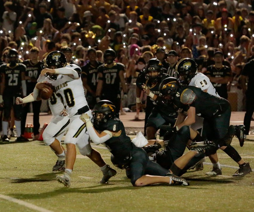 Rock Canyon's Aidan Duda tries to break free from the tackle of Joshua Acker of the Warriors Sept. 23 in Littleton.